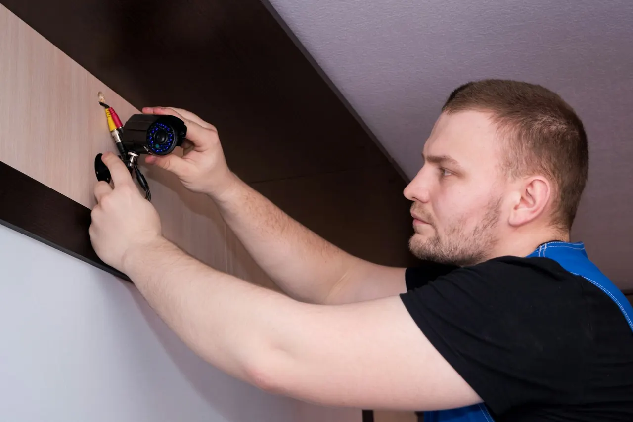 Technician fixing a CCTV camera to a wall