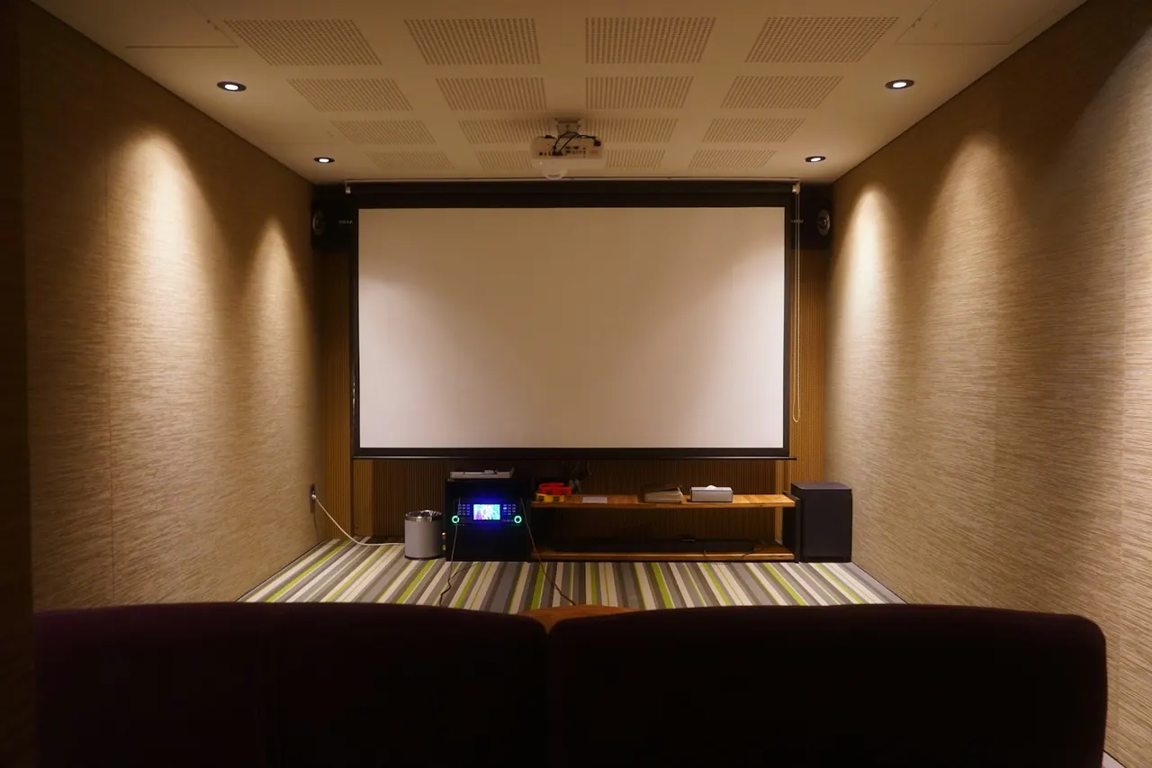 Home theatre room with a large projector screen and seating